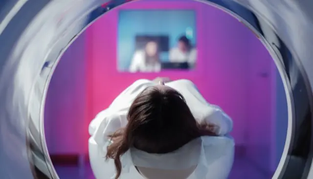 Blick aus der Gantry: Patientin in der Untersuchung, Team im Kontrollraum